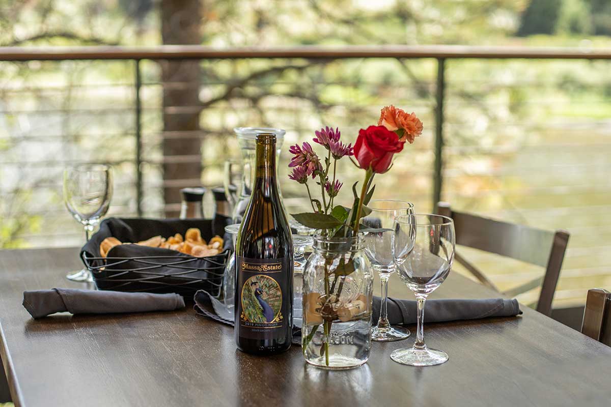 A Set Table On The Outdoor Patio Overlooking The River